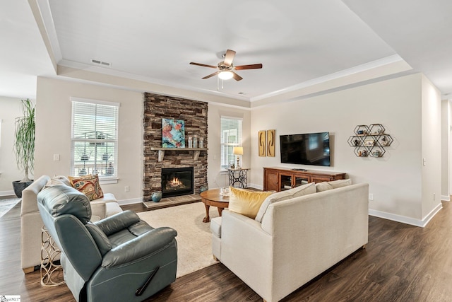 living room with a raised ceiling, visible vents, and dark wood finished floors