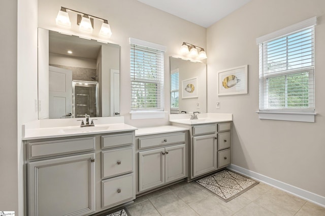 full bath with a healthy amount of sunlight, baseboards, a shower stall, and vanity