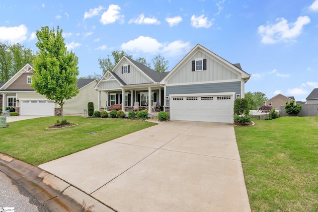 craftsman-style house with driveway, covered porch, board and batten siding, and a front yard