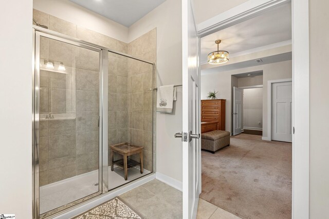 bathroom with a chandelier, baseboards, a shower stall, and tile patterned flooring