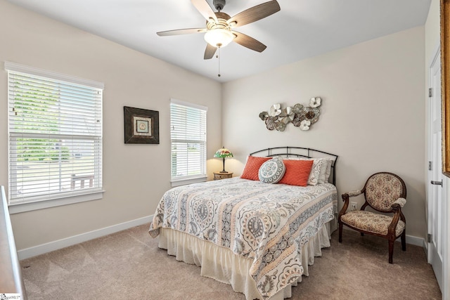 bedroom featuring ceiling fan, light carpet, and baseboards