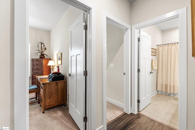 hallway featuring wood finished floors and baseboards