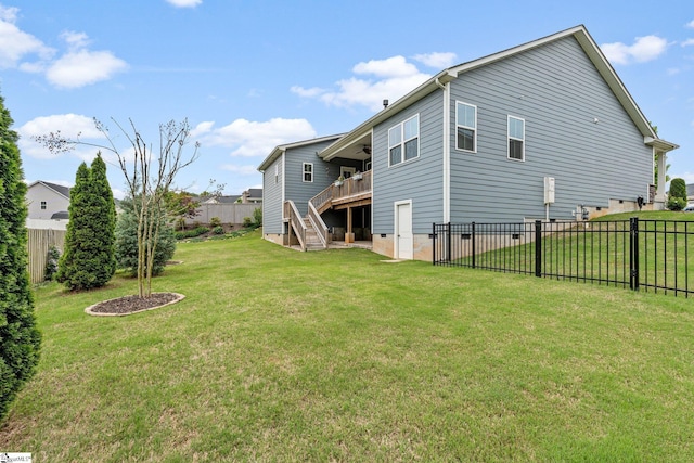 rear view of property with stairs, a deck, ceiling fan, a lawn, and a fenced backyard