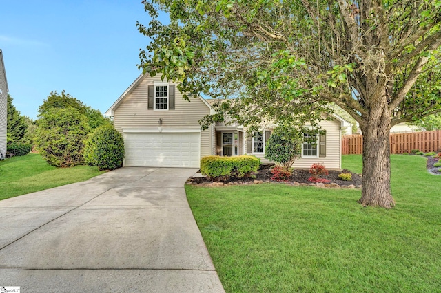 view of front of property with concrete driveway, a front lawn, and fence