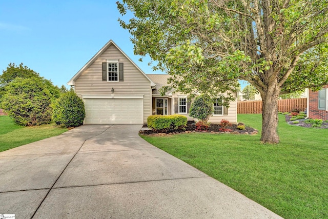 view of front of home featuring a front yard, driveway, an attached garage, and fence