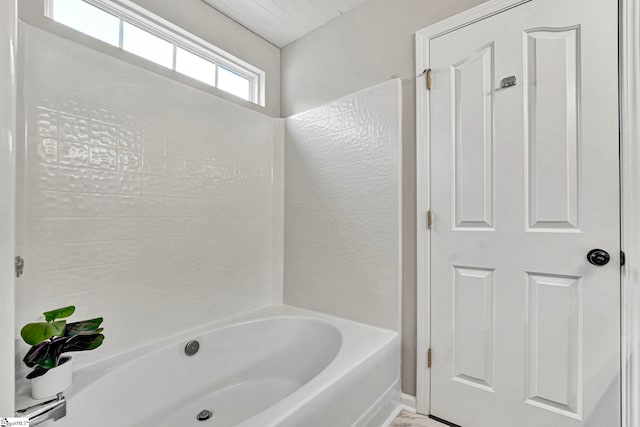 full bath featuring baseboards and washtub / shower combination