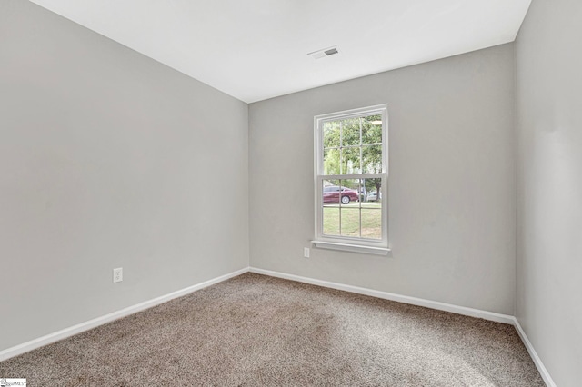 carpeted empty room with visible vents and baseboards