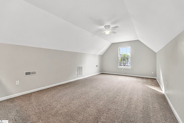 additional living space featuring visible vents, baseboards, carpet floors, vaulted ceiling, and a ceiling fan
