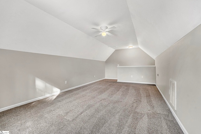 additional living space with a ceiling fan, visible vents, vaulted ceiling, baseboards, and carpet floors