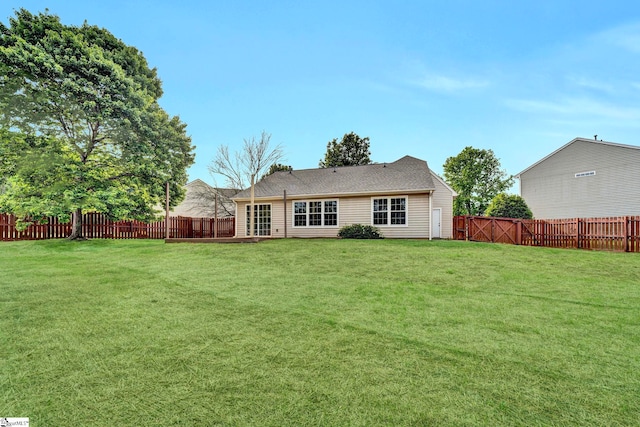 back of house featuring a lawn and a fenced backyard