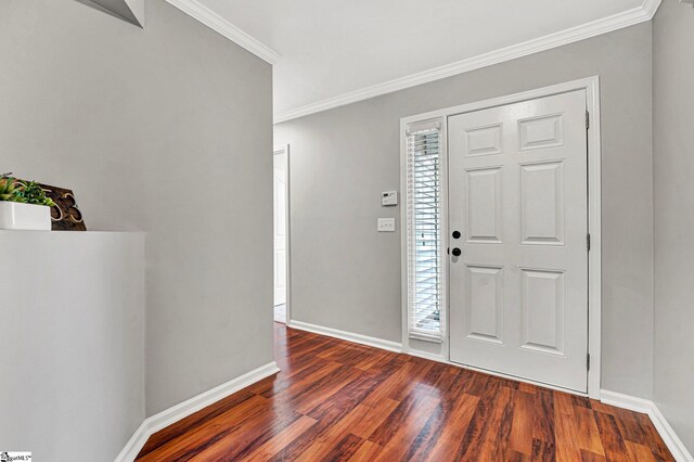 foyer featuring dark wood-style flooring, crown molding, and baseboards