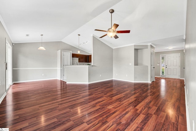 unfurnished living room with dark wood finished floors, vaulted ceiling, ornamental molding, ceiling fan, and baseboards