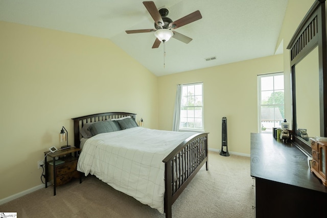 carpeted bedroom featuring a ceiling fan, visible vents, vaulted ceiling, and baseboards