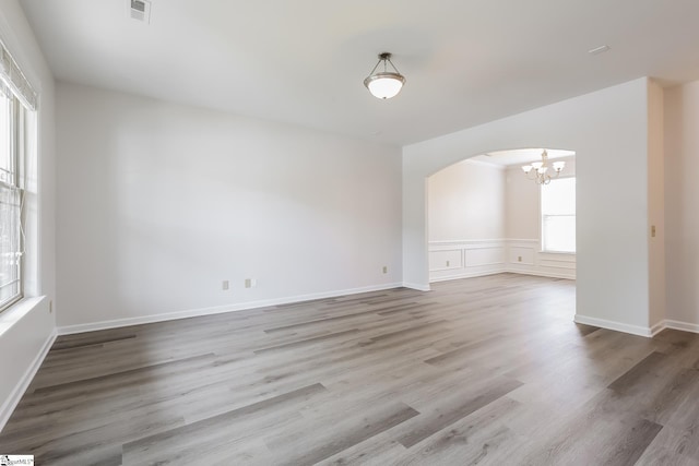 9 Dunsborough Dr, Simpsonville, SC 29680 - spare room featuring wood finished floors, visible vents, a notable chandelier, and arched walkways