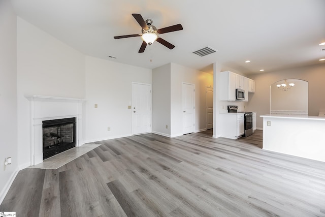 9 Dunsborough Dr, Simpsonville, SC 29680 - unfurnished living room with recessed lighting, ceiling fan with notable chandelier, a fireplace with flush hearth, and light wood-style flooring