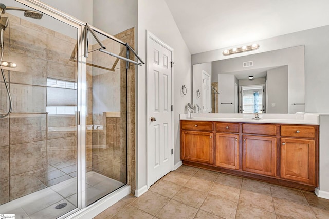 full bath with a shower stall, vanity, visible vents, vaulted ceiling, and baseboards