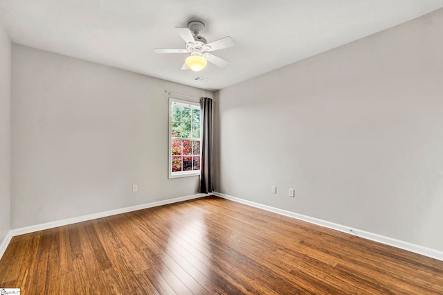 unfurnished room featuring a ceiling fan, visible vents, wood finished floors, and baseboards