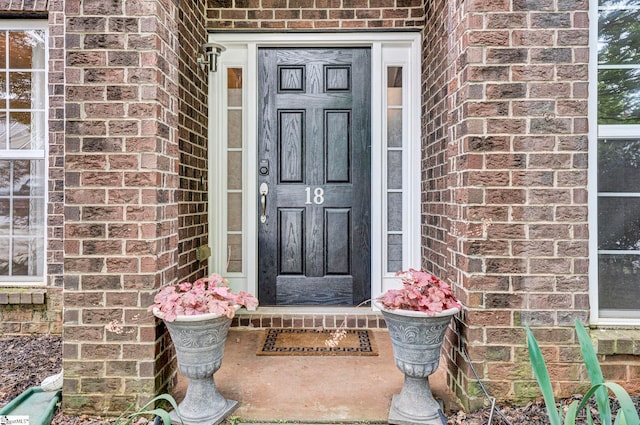 doorway to property with brick siding