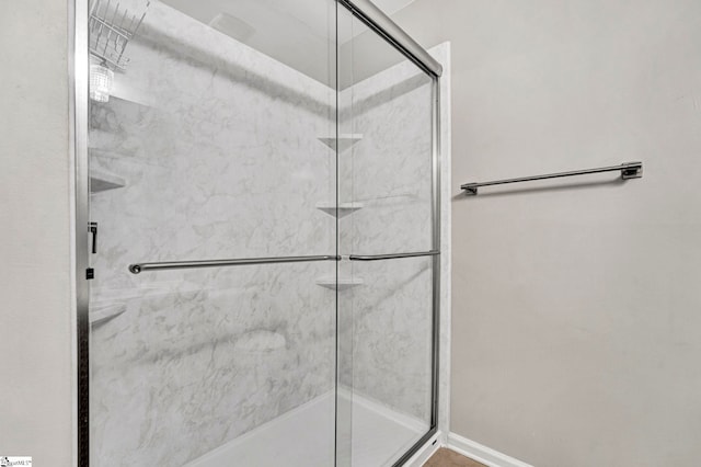 bathroom with a stall shower and baseboards