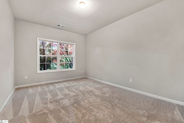 unfurnished room featuring baseboards, visible vents, and light carpet