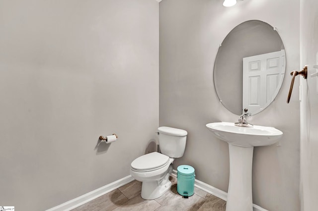 half bath with toilet and baseboards