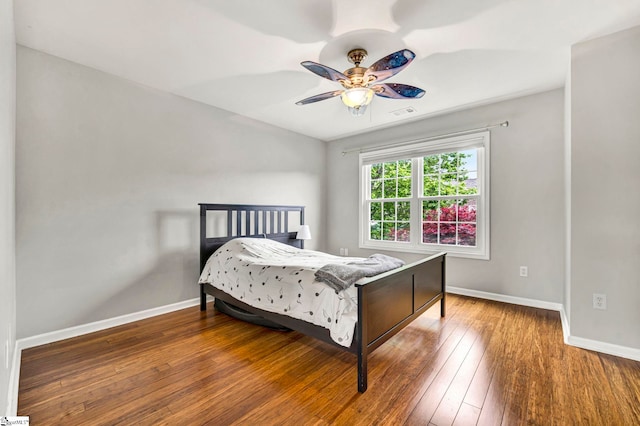 bedroom featuring a ceiling fan, hardwood / wood-style floors, and baseboards
