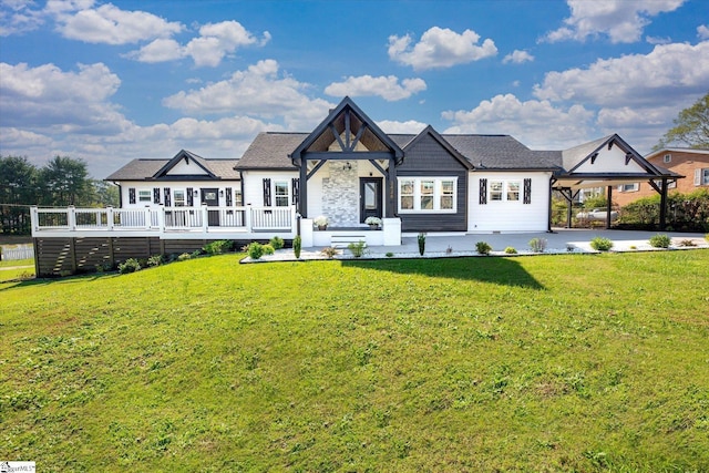 view of front of home featuring a deck, a front lawn, and stone siding