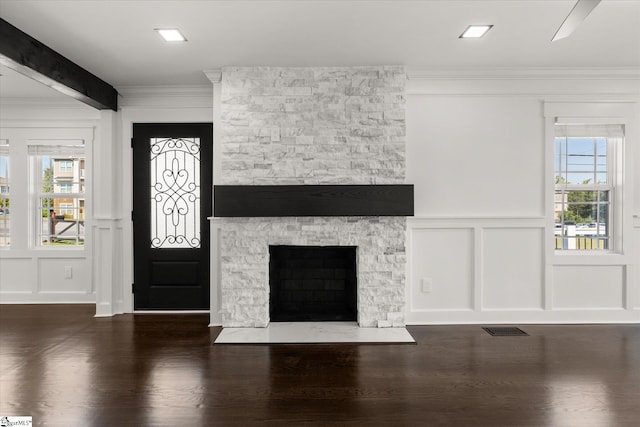 entryway with crown molding, wood finished floors, a decorative wall, and a healthy amount of sunlight