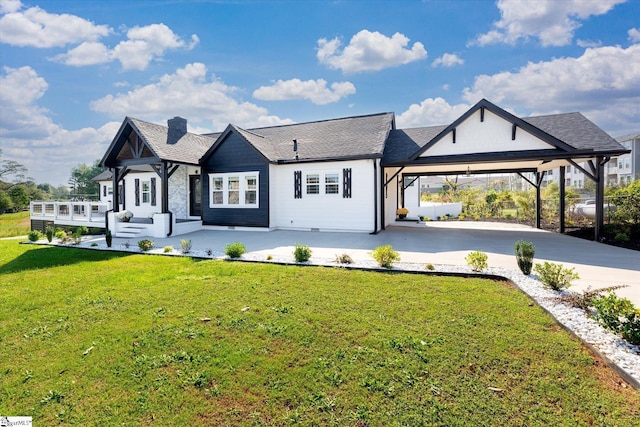 view of front of property with a chimney, a front yard, driveway, and an attached carport