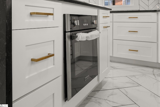 interior space with white cabinetry and dark countertops