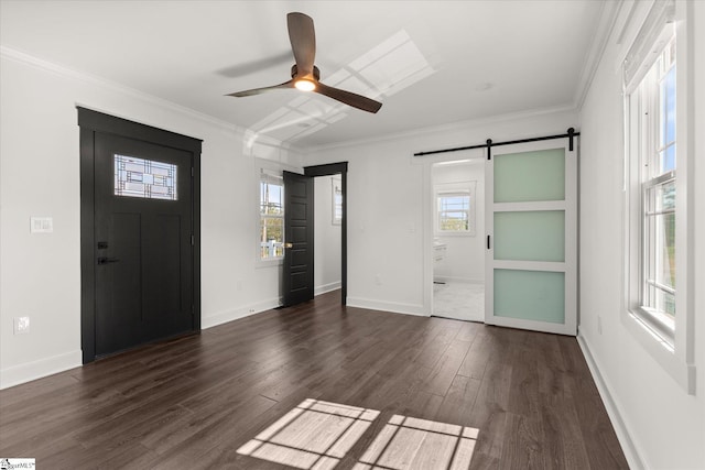 entrance foyer with dark wood-style floors, a barn door, a ceiling fan, baseboards, and ornamental molding