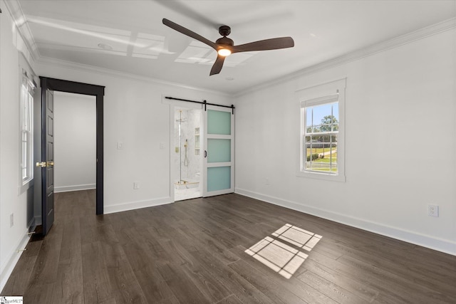unfurnished bedroom featuring connected bathroom, a barn door, baseboards, ornamental molding, and dark wood-type flooring