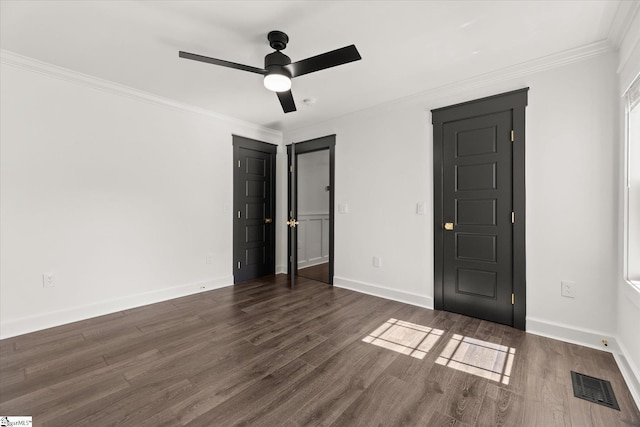 unfurnished bedroom with dark wood-type flooring, visible vents, and crown molding