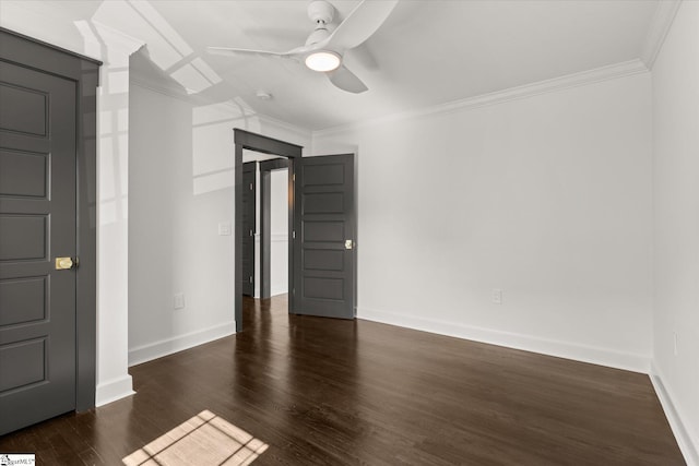 spare room with wood finished floors, ceiling fan, ornamental molding, and baseboards