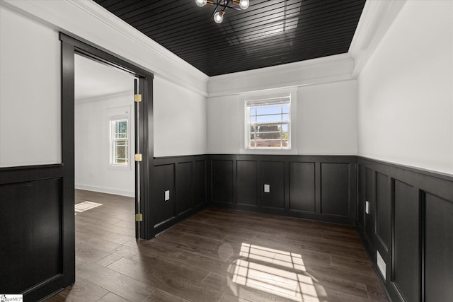 spare room featuring a wainscoted wall, plenty of natural light, ornamental molding, and dark wood-style floors