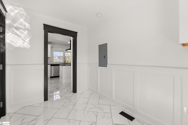 hall featuring electric panel, marble finish floor, a decorative wall, ornamental molding, and wainscoting