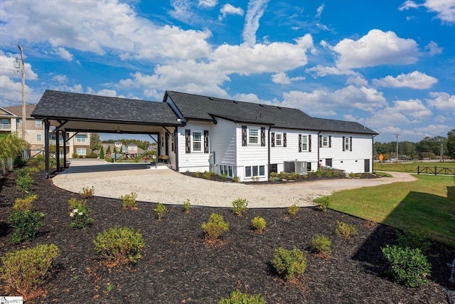 rear view of property with central air condition unit, a yard, gravel driveway, and fence