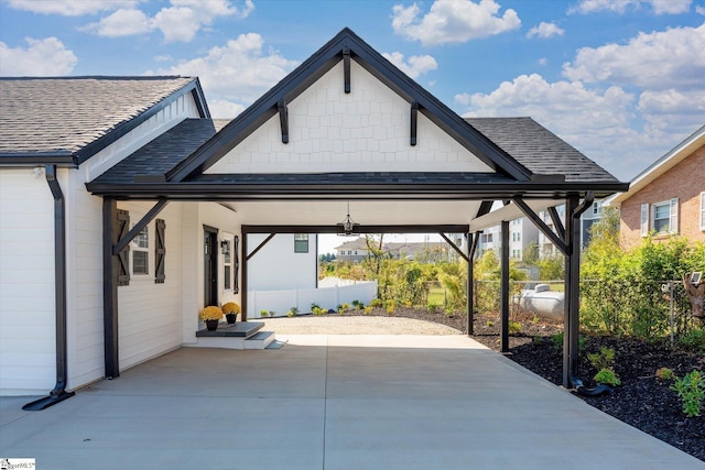 view of patio featuring concrete driveway and fence