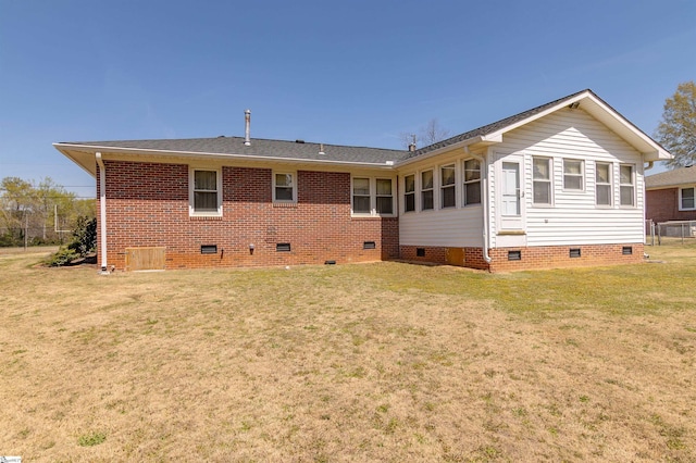 back of property with a lawn, crawl space, and brick siding