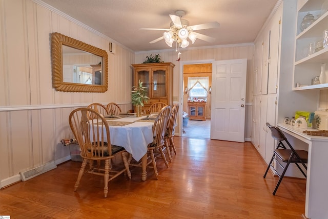 dining space featuring crown molding, a ceiling fan, visible vents, and light wood-style floors