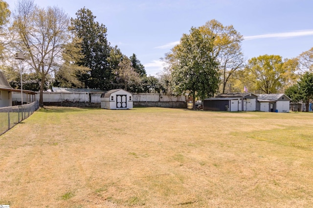view of yard featuring a fenced backyard, an outbuilding, and a storage shed