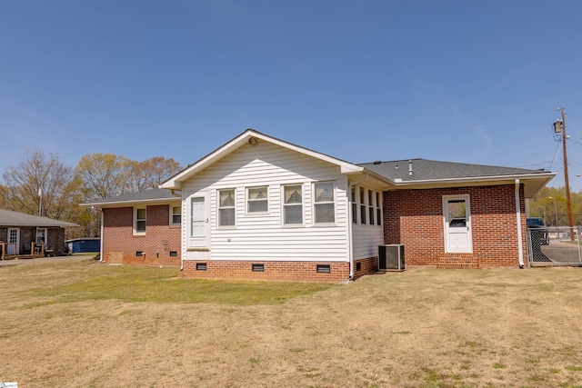 back of house with a lawn, a shingled roof, brick siding, and crawl space