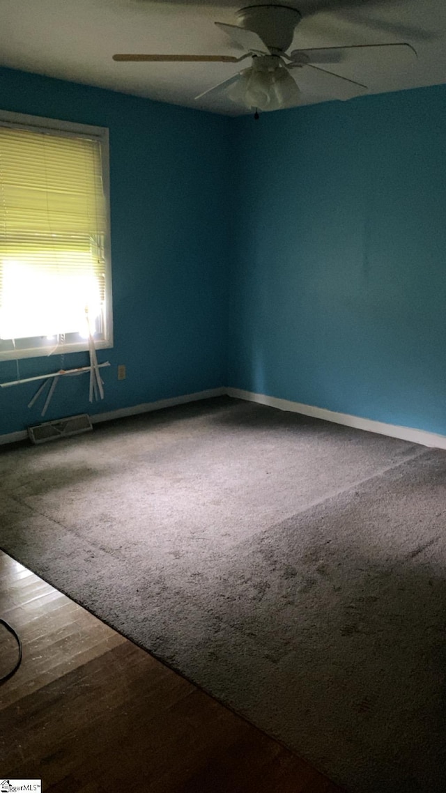 empty room featuring baseboards, ceiling fan, and carpet floors