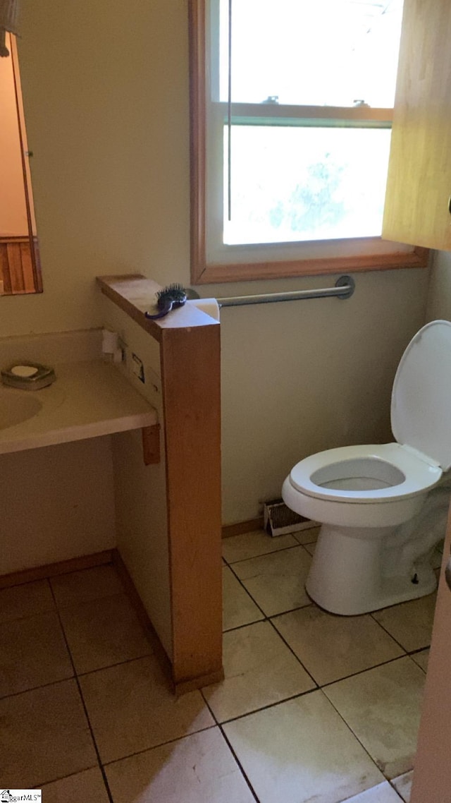 half bath with toilet and tile patterned flooring