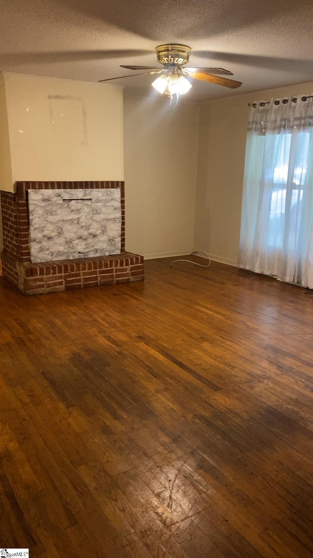 unfurnished living room featuring hardwood / wood-style floors, a ceiling fan, and a textured ceiling