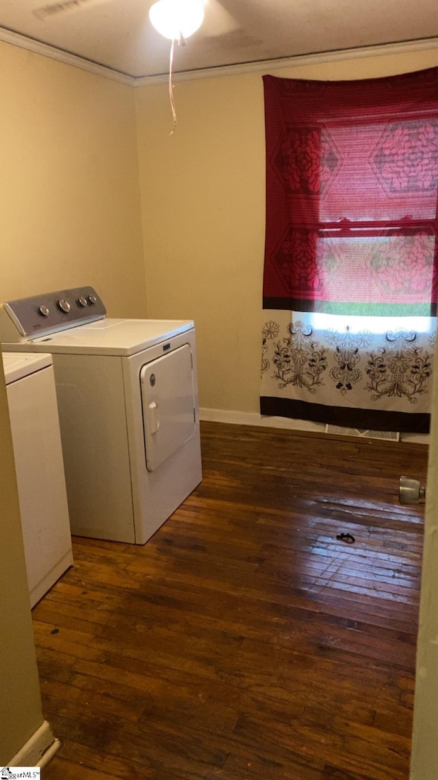 washroom with crown molding, baseboards, separate washer and dryer, dark wood finished floors, and laundry area