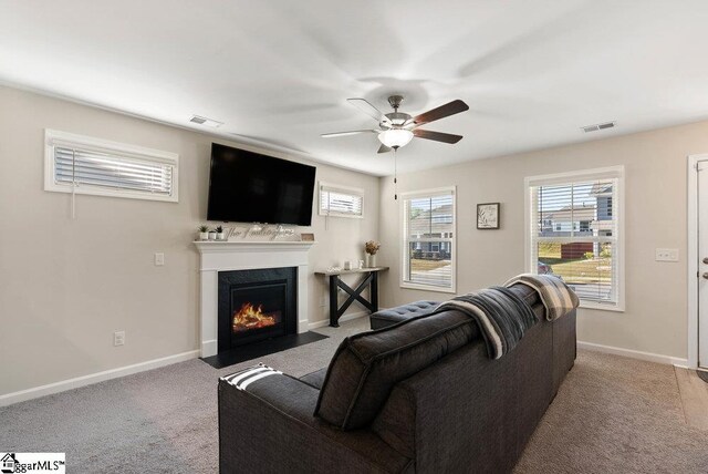 149 Bruinen Dr, Fountain Inn, SC 29644 - carpeted living area with baseboards, visible vents, a ceiling fan, and a fireplace with flush hearth