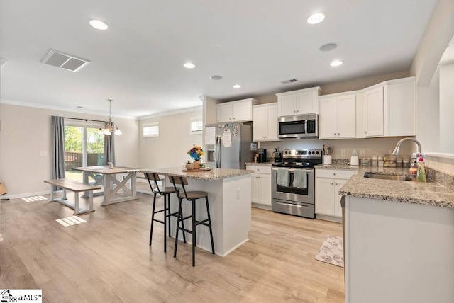 149 Bruinen Dr, Fountain Inn, SC 29644 - kitchen with a sink, stainless steel appliances, a kitchen bar, visible vents, and ornamental molding