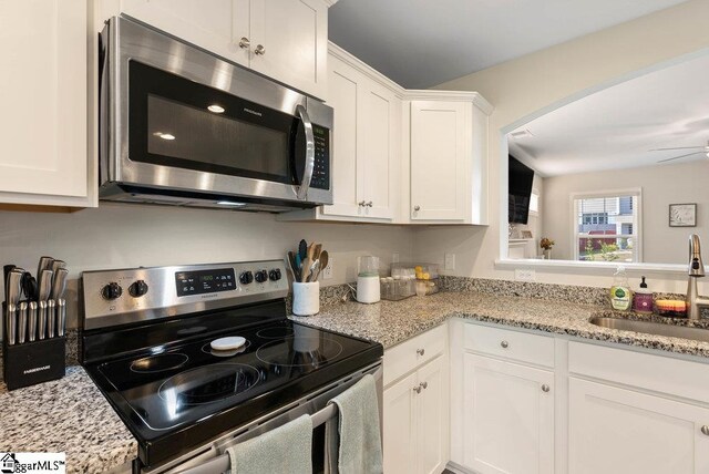 149 Bruinen Dr, Fountain Inn, SC 29644 - kitchen featuring light stone counters, white cabinetry, stainless steel appliances, and a sink