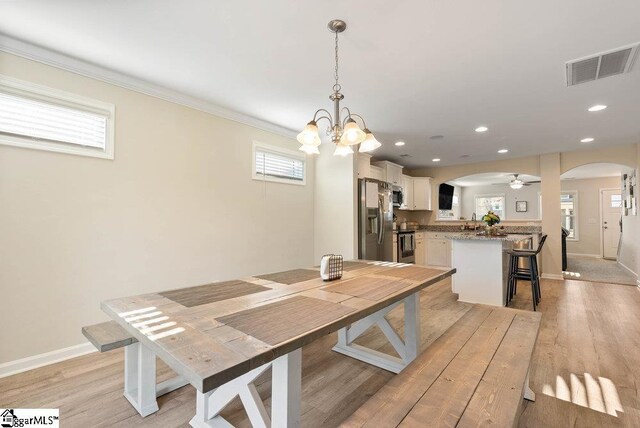 149 Bruinen Dr, Fountain Inn, SC 29644 - dining space featuring baseboards, visible vents, arched walkways, and crown molding